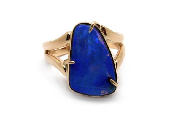 Solid black boulder opal claw set into yellow gold split band ring