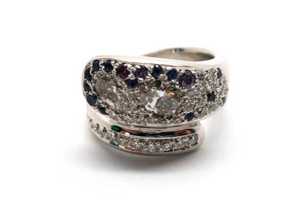 Oval and brilliant cut diamonds pave set in a overlapping style ring with purple sapphires