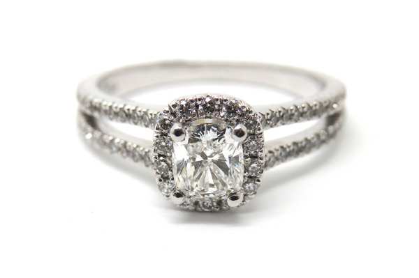 Split band claw set engagement ring with a cushion cut diamond surrounded by brilliant cut stones