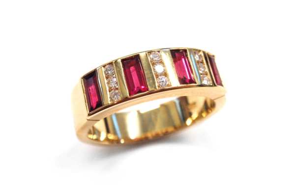 Natural baguette rubies set in between pave round diamonds in a yellow gold band