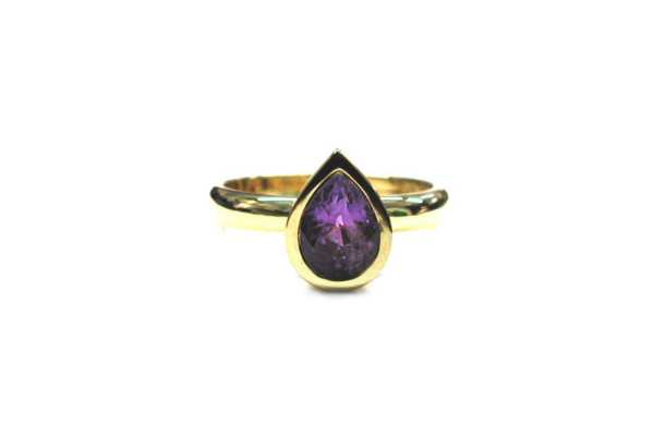 Pear shaped purple sapphire bezel set in yellow gold ring