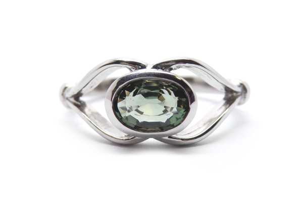 Natural green oval sapphire bezel set into open band ring