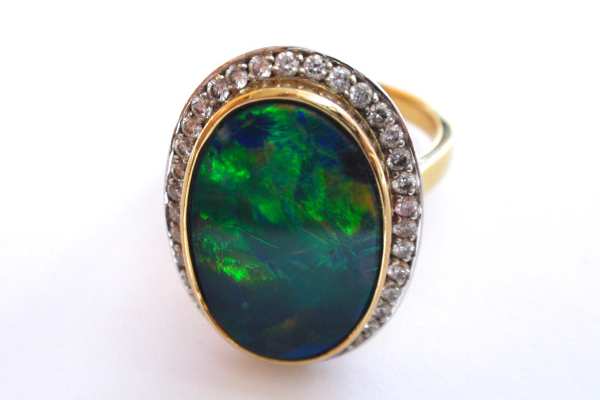 Bezel set opal with a halo of bead set diamonds