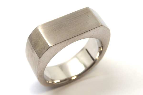 Hand carved men’s wedding ring with a solid angled top, satin finished