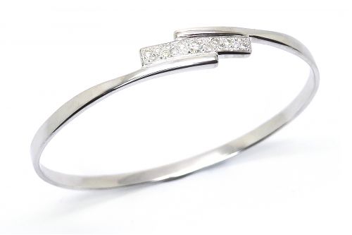 Oval profile white gold bangle with a diamond section, bead set across the top