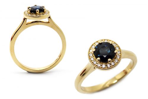 Dark round cut sapphire with a diamond halo set in yellow gold. Lifted to fit with a wedding band