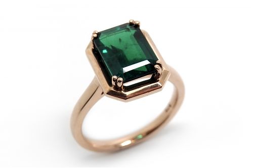 Emerald cut green tsavorite garnet claw set in a rose gold angled framed dress ring