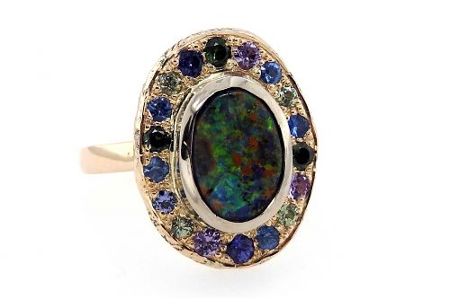 Multiple coloured sapphires surrounding a boulder opal in an organic oval halo ring