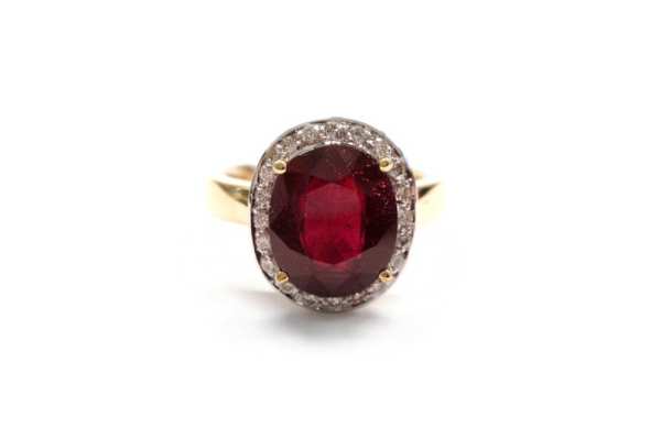Oval cut ruby claw set with a halo surround of pave brilliant cut diamonds 